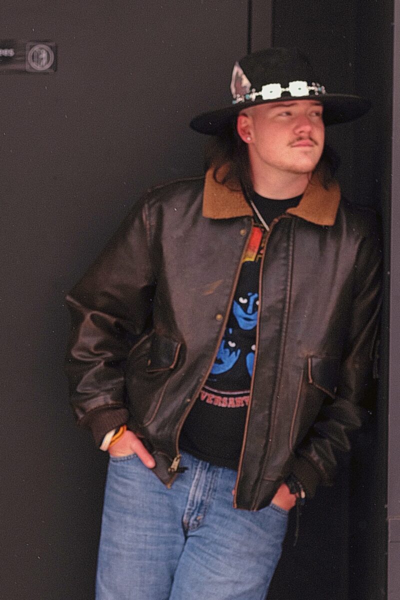 Country singer Patrick Lee standing up against a wall.